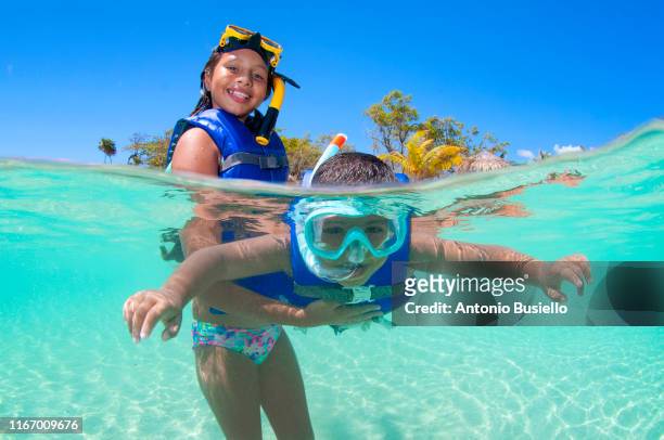 kids playing and snorkelling - honduras family stock pictures, royalty-free photos & images