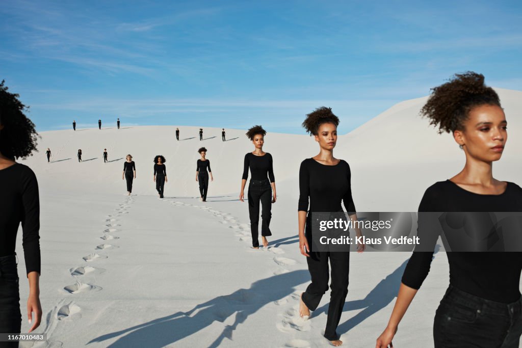 Multiple image of young female models walking at desert