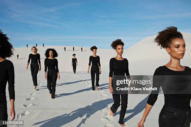 multiple image of confident young female models walking at desert - same people different clothes - fotografias e filmes do acervo