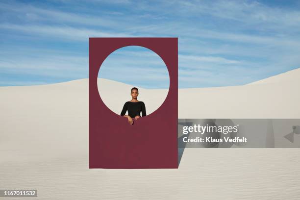 portrait of young woman looking through window frame at white desert - vista posterior stock pictures, royalty-free photos & images