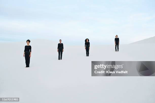 female models standing at white desert against sky during sunset - pessoas em fila imagens e fotografias de stock