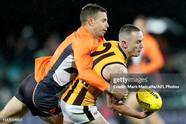 Tom Scully of the Hawks is tackled by Brett Deledio of the Giants during the round 21 AFL match between the Greater Western Sydney Giants and the...