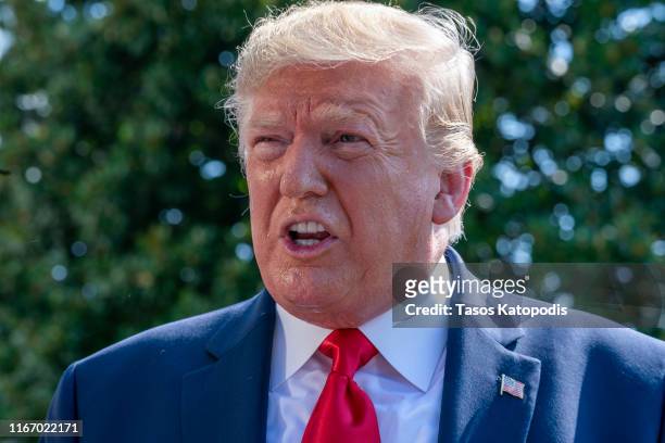 President Donald Trump speaks to members of the press before departing from the White House on the south lawn before he boards Marine One on August...
