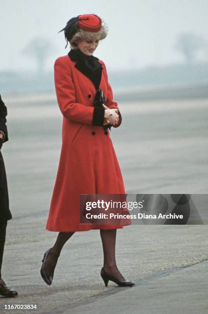 Diana, Princess of Wales wearing a red Catherine Walker coat and a hat by John Boyd upon her arrival at Birmingham airport, England, February 1984.