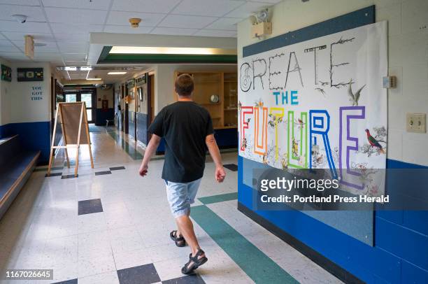 After returning a safety vest he uses for his job as a traffic guard, Joshua Strong walks down a hallway at Great Salt Bay Community School in...