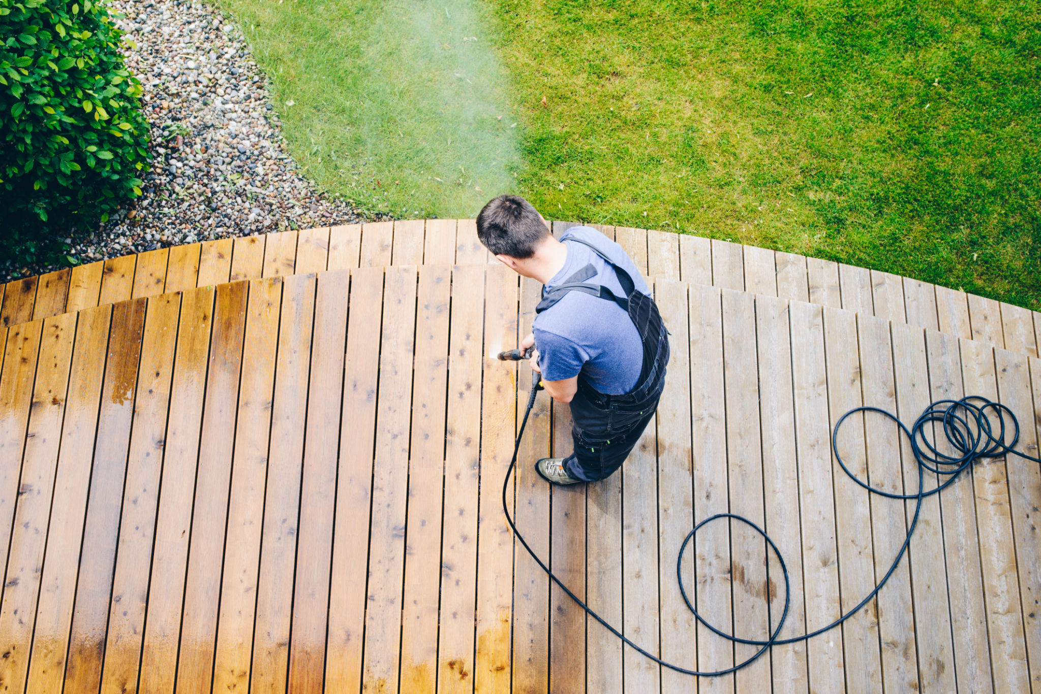 cleaning terrace with a power washer - high water pressure cleaner on wooden terrace surface cleaning terrace with a power washer - high water pressure cleaner on wooden terrace surface