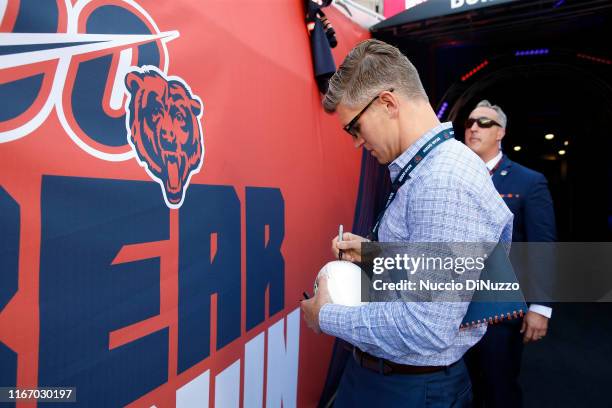 Chicago Bears general manager Ryan Pace signs a football for a fan prior to a preseason game against the Carolina Panthers at Soldier Field on August...