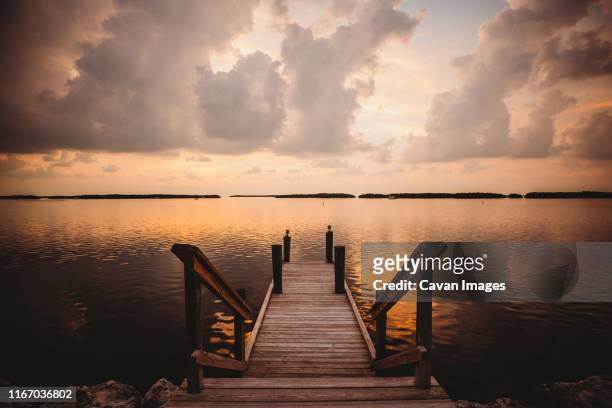a dock at sunset in the florida keys is the perfect spot for relaxing - islamorada stock-fotos und bilder