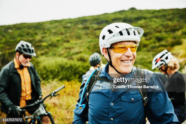 Portrait of smiling senior man hanging out with friends before early morning mountain bike ride