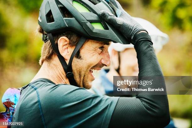 laughing mature man hanging out with friends after mountain bike ride - ropa protectora deportiva fotografías e imágenes de stock