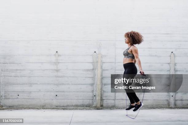 curvy african american woman skipping rope in urban area - cardiovascular exercise stock pictures, royalty-free photos & images