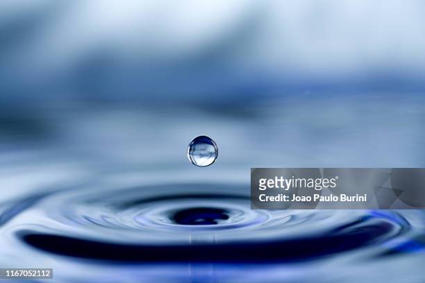 blue water drop close-up - slow motion stock pictures, royalty-free photos & images