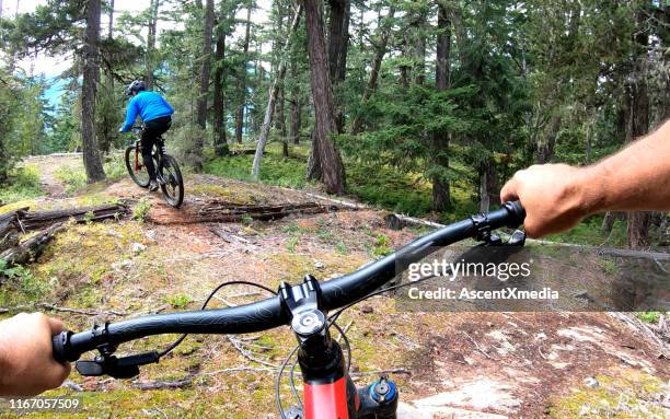 mountain bikers follow trail through forest - cross country cycling stock pictures, royalty-free photos & images