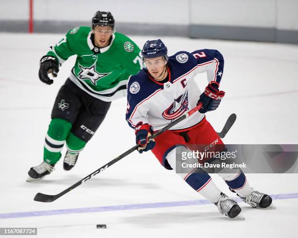 Andrew Peeke of the Columbus Blue Jackets skates up ice with the puck in front of Riley Damiani of the Dallas Stars during Day-4 of the NHL Prospects...