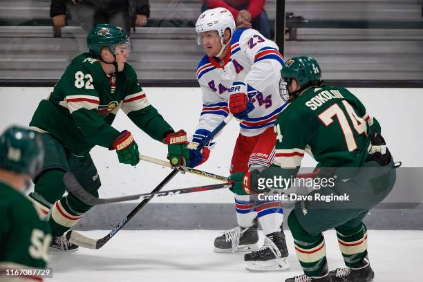 Adam Fox of the New York Rangers shoots the puck between Alex Breton and Dmitry Sokolov of the Minnesota Wild during Day-4 of the NHL Prospects...