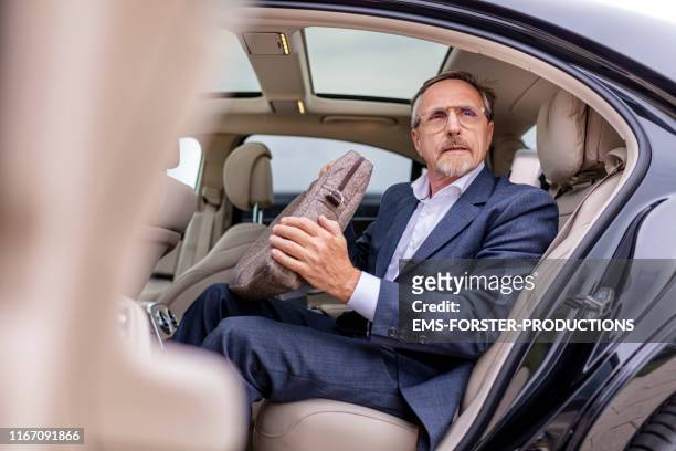 happy businessman exiting the limousine - laptop bag stock pictures, royalty-free photos & images
