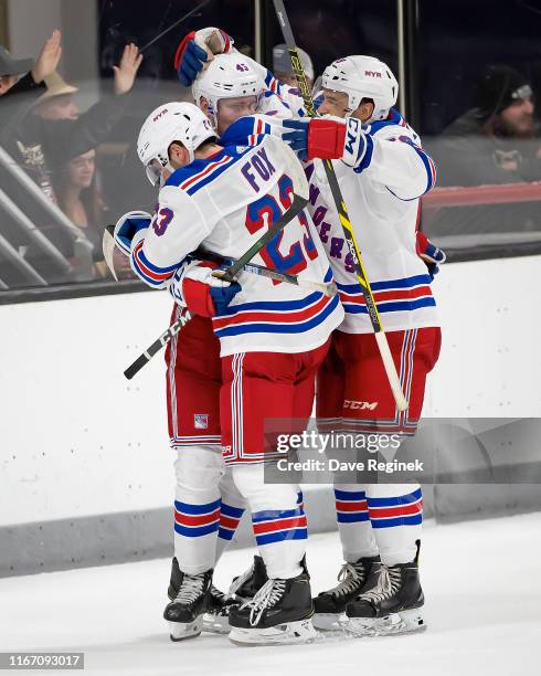 Kaapo Kakko of the New York Rangers celebrates his game winning O.T. Goal against the Minnesota Wild with teammates Adam Fox and Ryan Dmowski during...