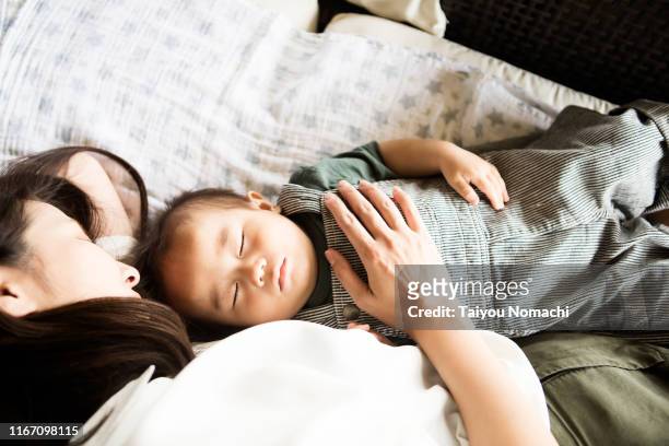 mother snuggling up to sleeping son - 赤ちゃん　寝る ストックフォトと画像