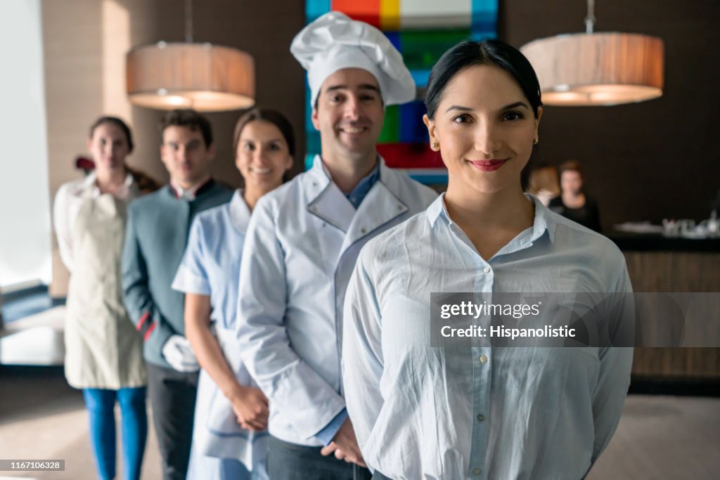 豪華酒店的專業酒店員工都面對鏡頭微笑站在女經理身後