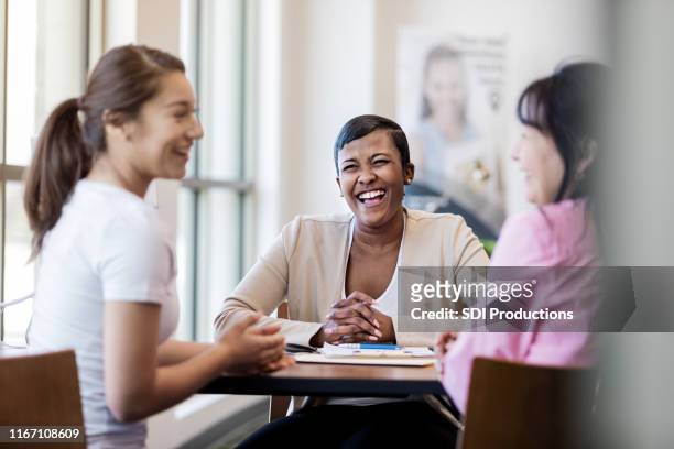banker laughs as daughter jokes with mother - financial advisor with family stock pictures, royalty-free photos & images