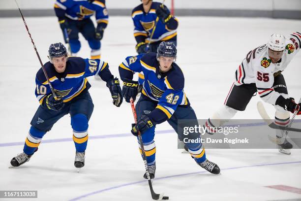 Jeremy Michel and Keean Washkurak of the St. Louis Blues skates up ice with the puck next to Cole Purboo of the Chicago Blackhawks during Day-4 of...