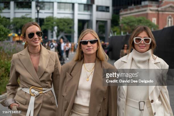 Tine Andrea wearing beige jacket, silk skirt and Darja Barannik wearing turtleneck, white coat, and flared pants attend the Carolina Herrera show...
