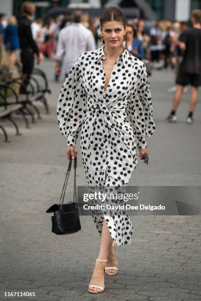 Actress Alexandra Daddario is seen wearing a black and white polka dot dress, white strappy sandals, and a black shoulder bag at the Garden of the...