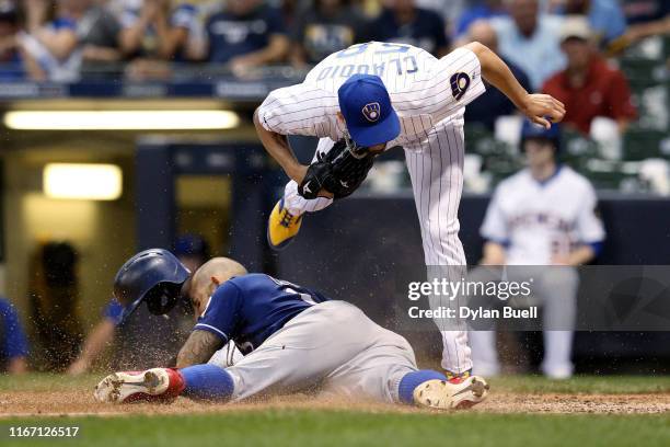 Alex Claudio of the Milwaukee Brewers tags out Rougned Odor of the Texas Rangers at home plate in the sixth inning at Miller Park on August 09, 2019...