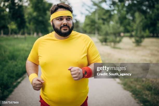 young large build guy jogging in park - sweat band stock pictures, royalty-free photos & images