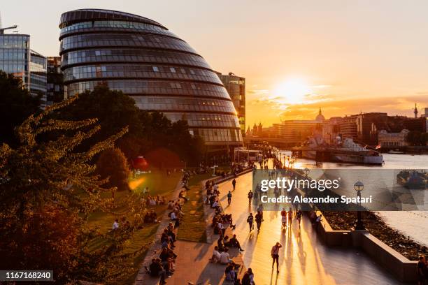 london city hall and people walking along thames river at sunset, london, england, uk - la city de londres photos et images de collection