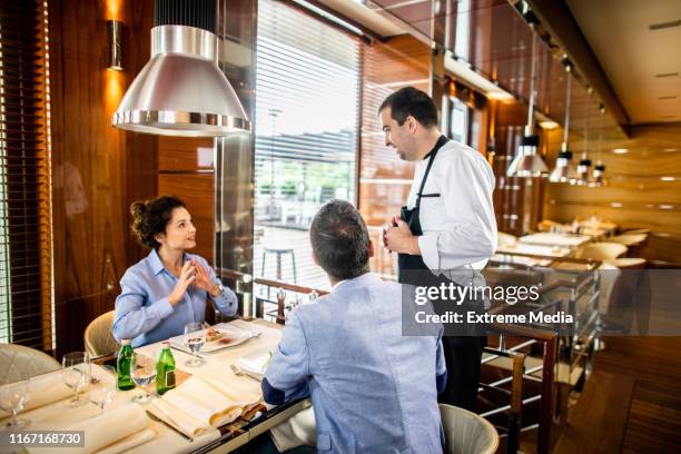 chef explicando su especialidad a una pareja almorzando en un restaurante - cocina molecular fotografías e imágenes de stock