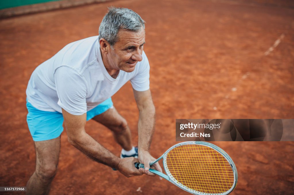 Man Using Tennis Racket Older Man Holding Tennis Racket On Court High-Res Stock Photo - Getty ...
