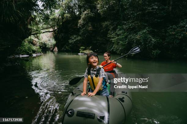 cheerful young girl having fun on kayak with mother in rainforest, japan - adventure family stock pictures, royalty-free photos & images