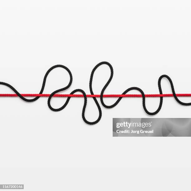 curved black rope around straight red rope - knoten lösen stock-fotos und bilder