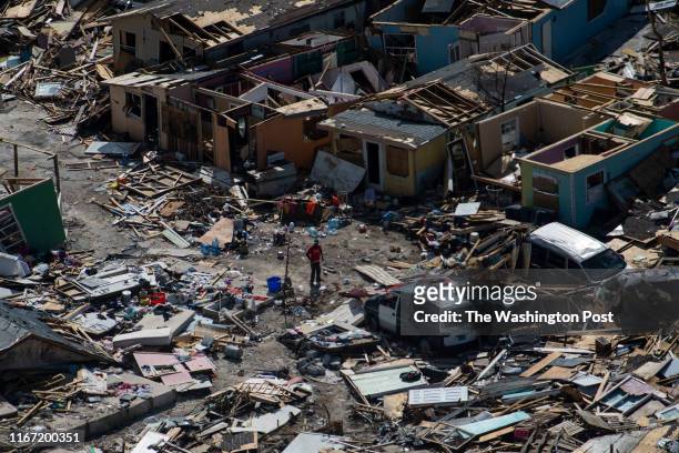 Man goes through damage and debris is seen in the Mudd and the Peas neighborhoods of Marsh Harbour, Bahamas after Hurricane Dorian on September 9,...