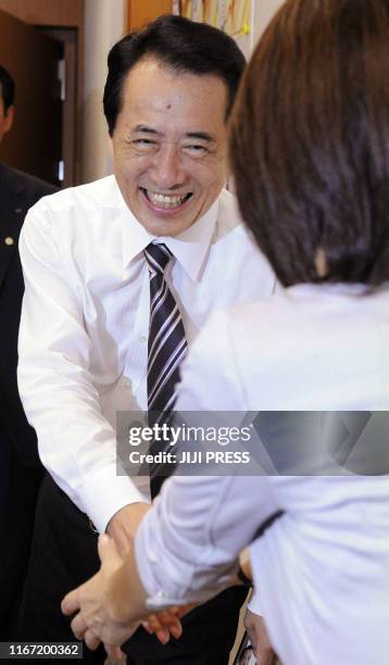 Japanese Prime Minister Naoto Kan shakes the hands of supporters during his election campaign for DPJ lawmakers in Tokyo on September 13 one day...