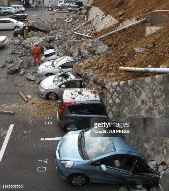 Vehicles are crushed by a collapsed wall at a carpark in Mito city in Ibaraki prefecture on March 11, 2011 after a massive earthquake rocked Japan....