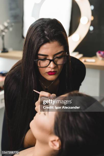 attentive makeup artist at work - maquilhador imagens e fotografias de stock