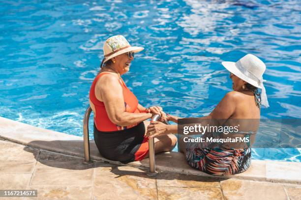 mature women enjoying summertime - friends poolside stock pictures, royalty-free photos & images