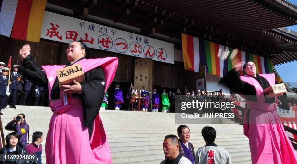 Estonlian sumo champion Baruto and Japanese sumo wrestler Kisenosato throw small bags containing beans during a bean-throwing ceremony to drive away...