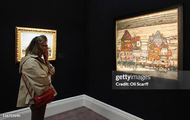 Woman admires a painting by Egon Schiele entitled "Hauser mit bunter Wasche" in Sotheby's auction house on June 17, 2011 in London, England. The...