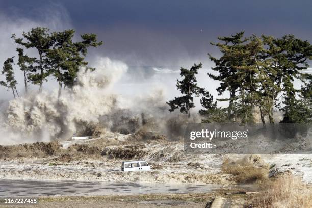 This picture taken on March 11, 2011 by Sadatsugu Tomizawa and released via Jiji Press on March 21, 2011 shows tsunami waves hitting the coast of...