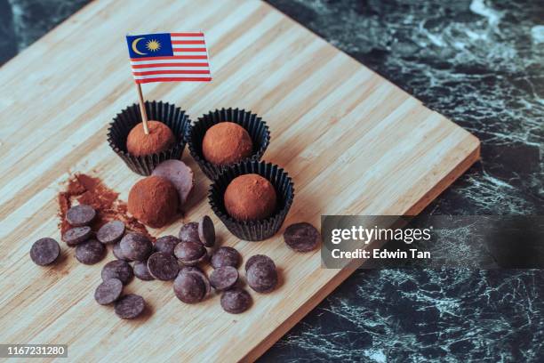 chocolate truffles on cutting board with malaysian flag and chips celebration of malaysia independence day - lamington cake stock pictures, royalty-free photos & images