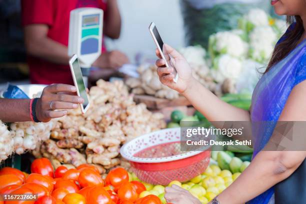 女人在街頭小販那裡買菜。庫存照片 - india market 個照片及圖片檔