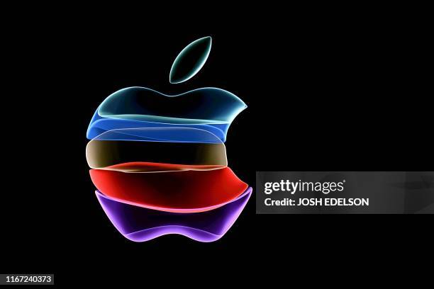 The apple logo is projected on a screen before the start of a product launch event at Apple's headquarters in Cupertino, California, on September 10,...
