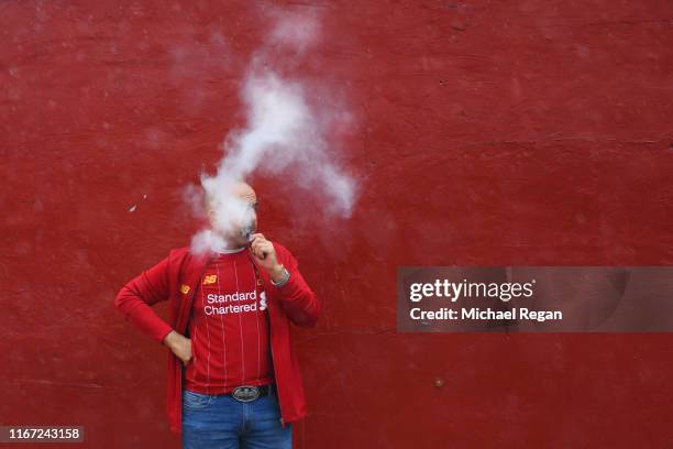Liverpool fan vapes outside the ground before the Premier League match between Liverpool FC and Norwich City at Anfield on August 09, 2019 in...