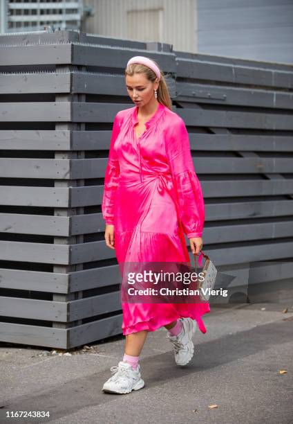 Guest is seen wearing pink dress, sneaker, Louis Vuitton bag outside Munthe during Copenhagen Fashion Week Spring/Summer 2020 on August 07, 2019 in...