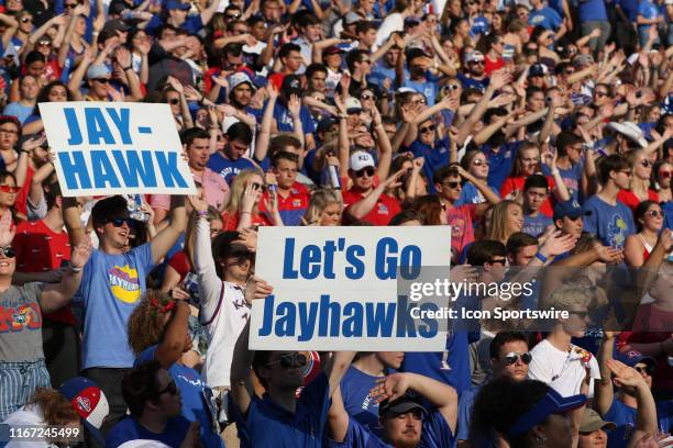 Kansas Jayhawk fans hold up "Let's Go Jayhawks" signs as well as "Waiving the Wheat" in the first quarter of an FBS football game between the Coastal...