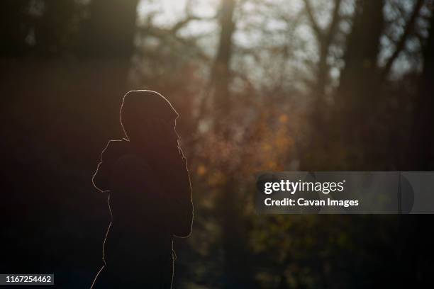 side profile of asian woman enjoying the cold weather blowing mist - rim light portrait stock pictures, royalty-free photos & images