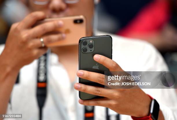 Man takes a photo of the new Apple 11 Pro during an Apple product launch event at Apple's headquarters in Cupertino, California on September 10,...